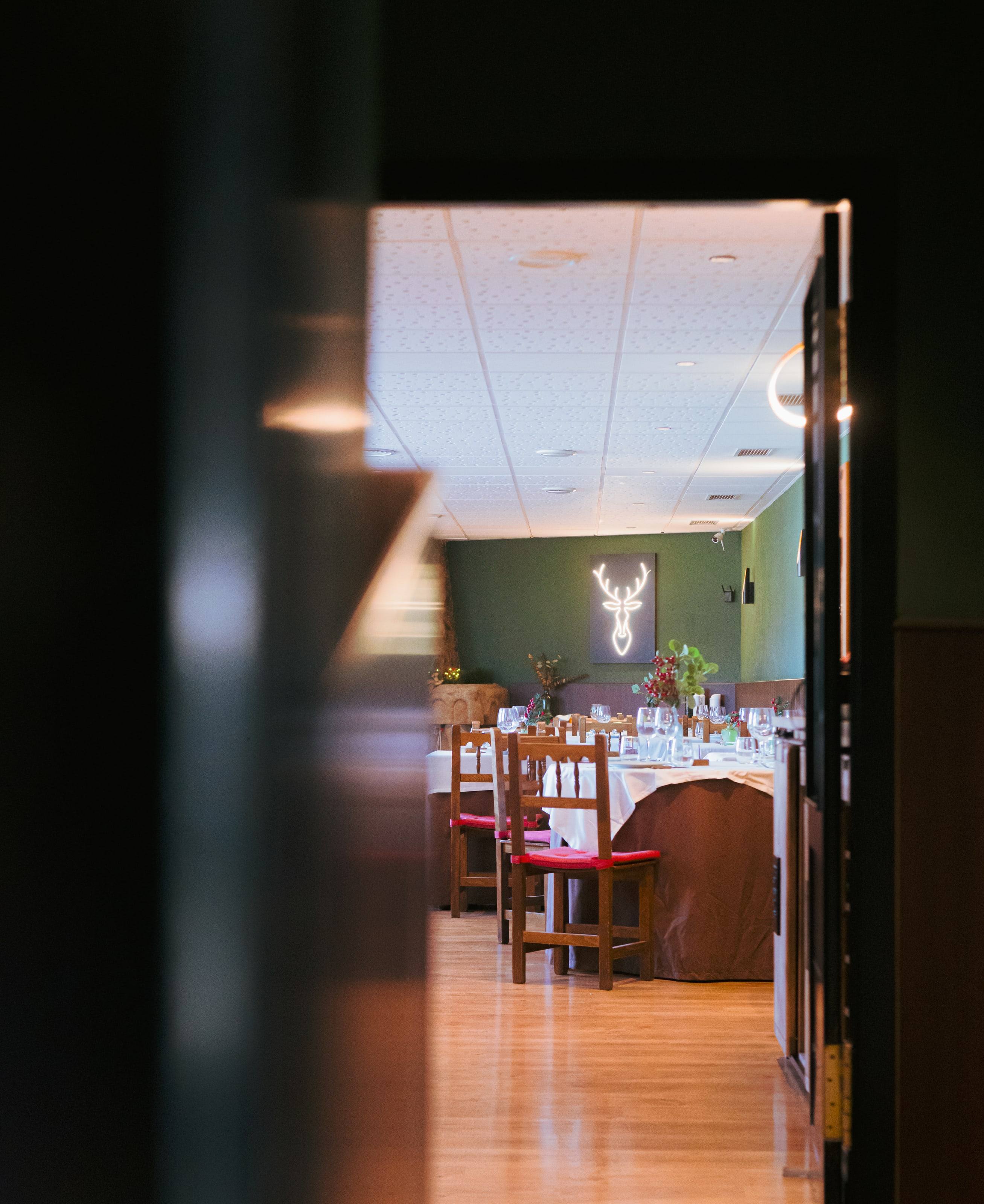 El comedor de Grand Prix visto a través de una puerta, con el ciervo de neón al fondo.