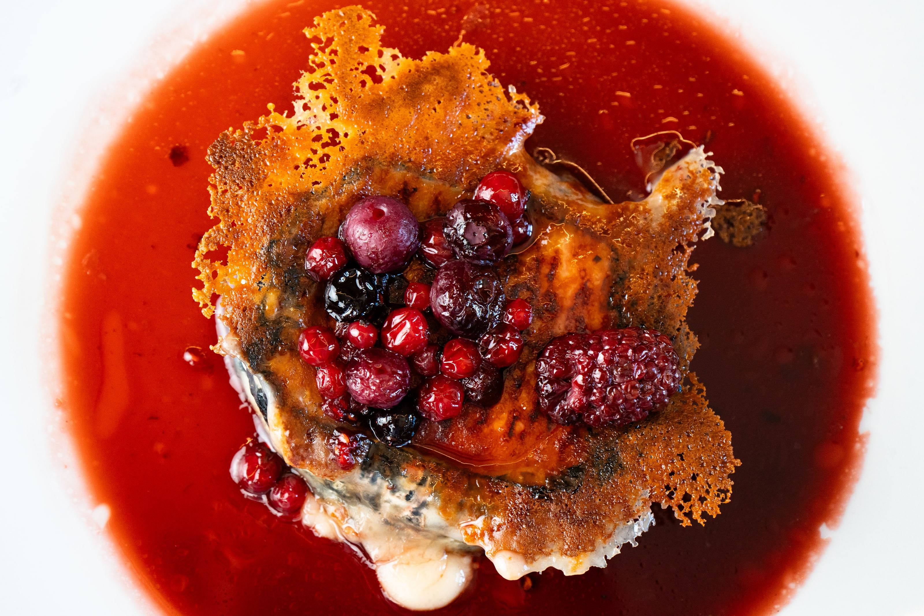 Detalle de frutos rojos y crujiente de caramelo, postre del restaurante Raíces.