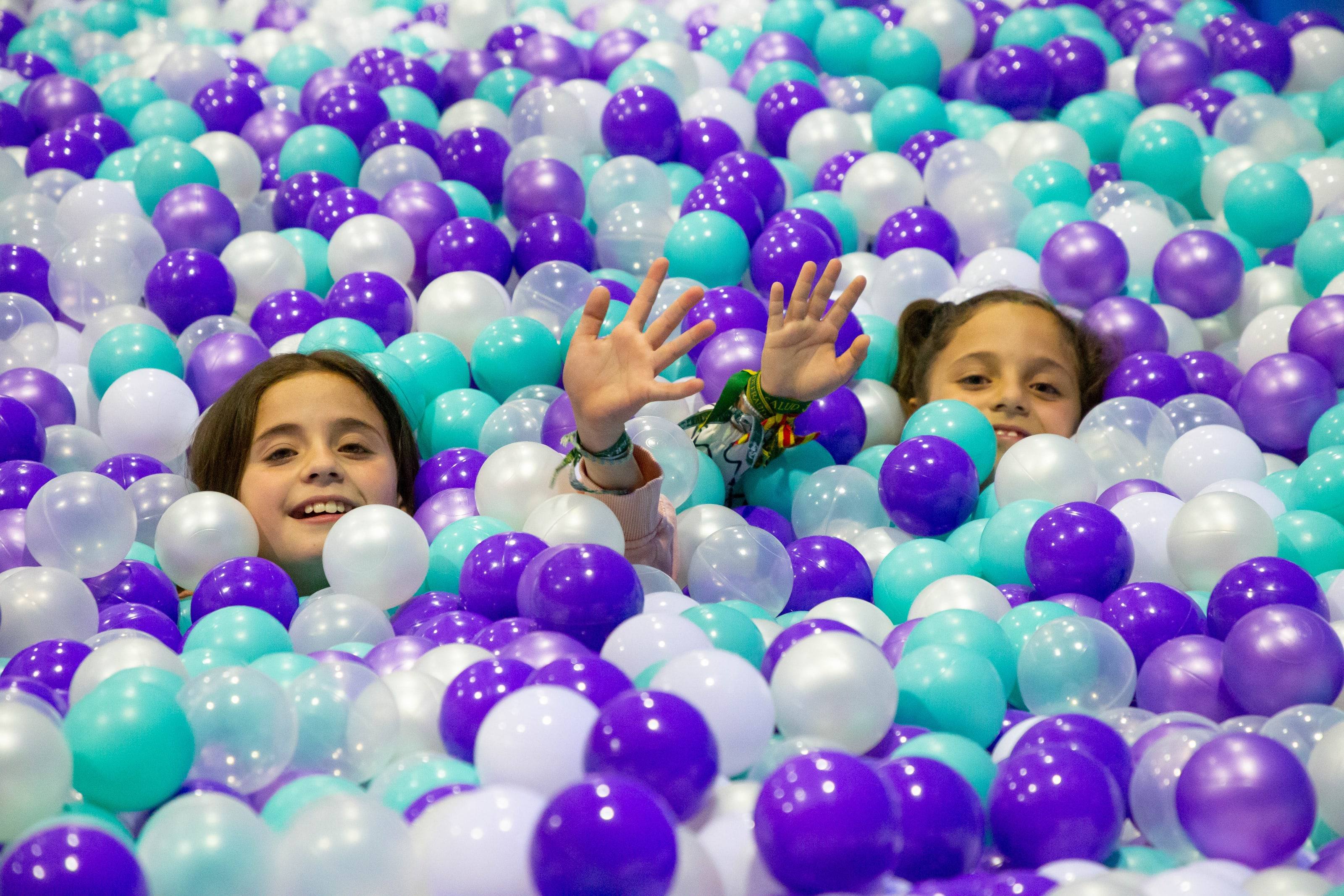 Niños jugando en una piscina de bolas de colores en el parque Go Jumping.